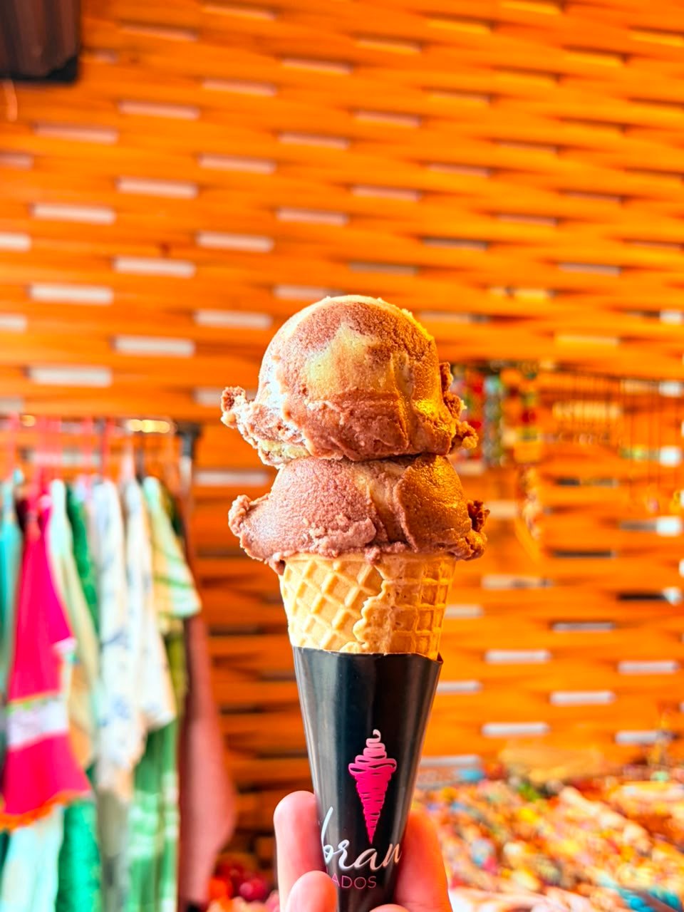 Cono de Helados Gibran con dos bolas frente a un mercado colorido de CDMX